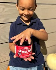 A child opening a Kids Multi jar outdoors.