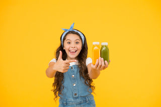 Vitamin B6 for kids: happy girl holding 2 bottles of juice