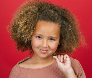 Chewable vitamins vs pills: little girl holding a chewable vitamin