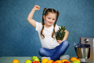 Immune system vitamins for kids: little girl holding a pineapple