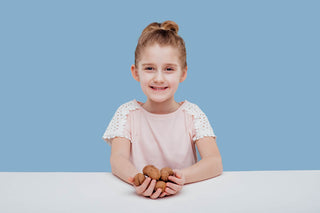 Omega 3 6 9: little girl holding a handful of walnuts