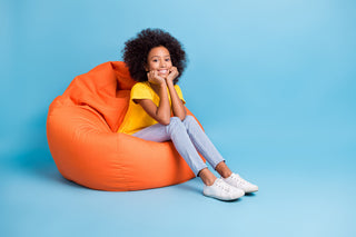 Vitamin B1 for kids: happy girl sitting on a bean bag