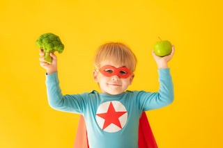 riboflavin for kids: little boy in superhero costume holding food
