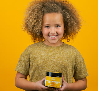 Child holding probiotics for kids container