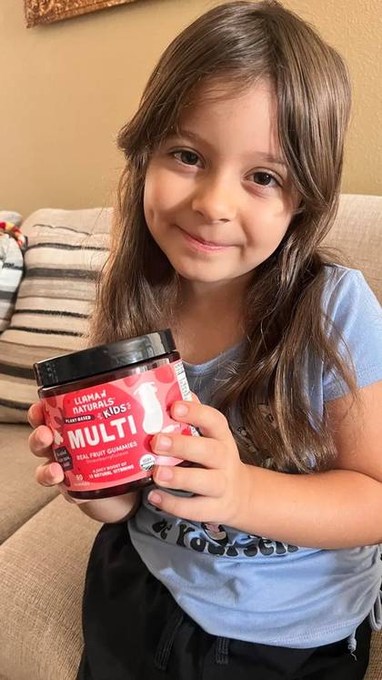 A child holding a Kids Multi jar at home.