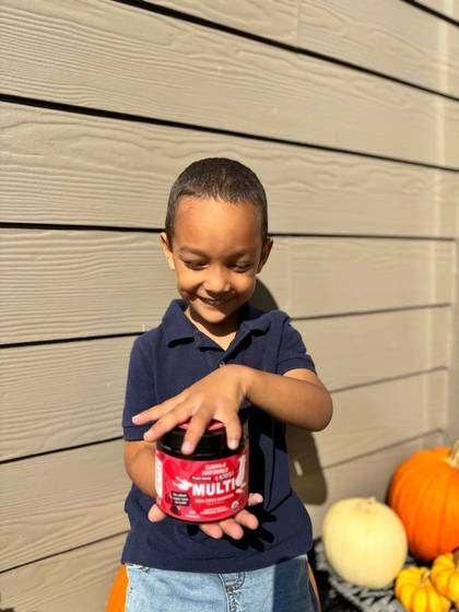 A child opening a Kids Multi jar outdoors.